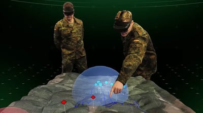 German soldiers wearing Microsoft HoloLens 2, discussing a training mission over a 3D holographic topology map.