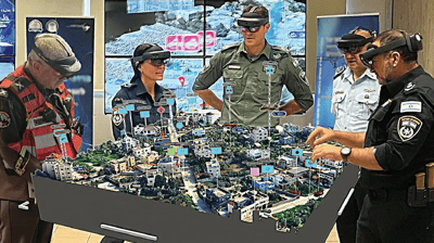 A group of people wearing AR headsets inspecting a 3D map of a city with overlaid real time data in augmented reality.