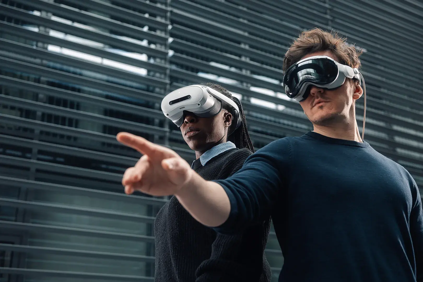 Two people working together in XR using different headsets.